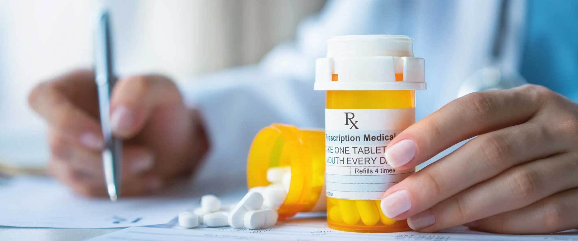 Prescription bottle with drugs being dispensed